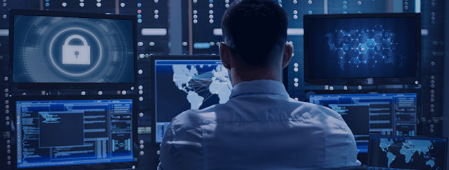 Network admin observing multiple monitors.