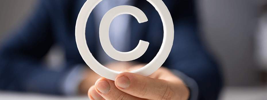 Man's hand holding copyright symbol