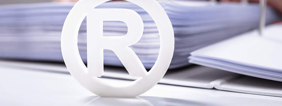 Registered symbol infront of a large binder full of documents