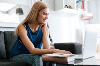 White woman in blue shirt contemplating